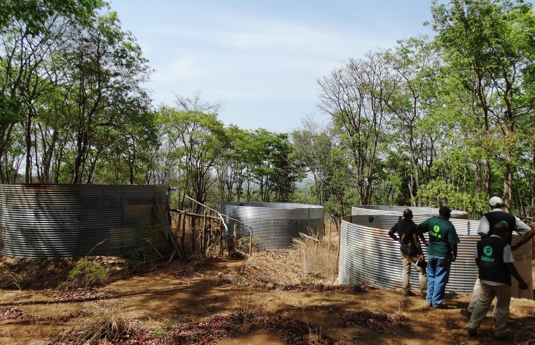 Oxfam staff inspect water tanks in Nduta refugee camp.