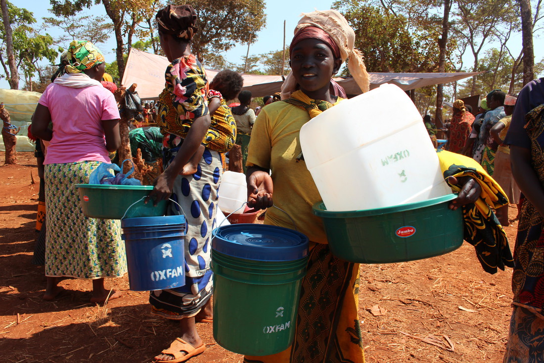 Refugees collect Oxfam water and sanitation equipment in Nyarugusu camp