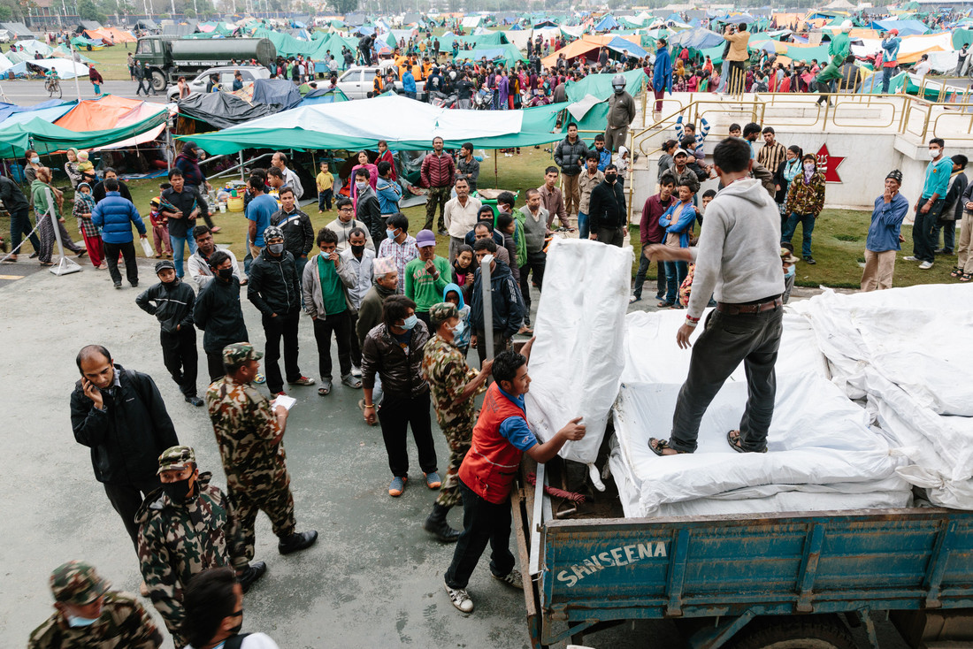 Shekhou Khadka, 23, works to off load latrines being delivered to Tundikhel camp, Nepal. Photo: Aubrey Wade/Oxfam