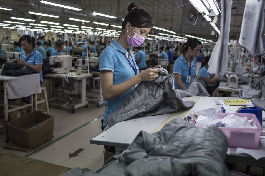 A woman works on a clothing line making winter jackets for an international brand in a garment factory in Dong Nai province, Vietnam, on November 21, 2017.