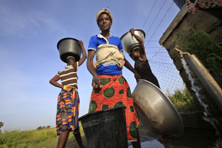 Felicia Ayaawin puise de l’eau dans le puits installé par le partenaire d'Oxfam près de sa maison à Kpatua. 