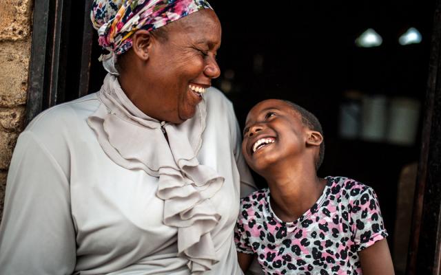 Paulina Sibanda sentada con su hija Tafara * (9) fuera de su casa en la región de Zvishevane, Zimbabwe. Crédito: Aurelie Marrier d'Unienville / Oxfam