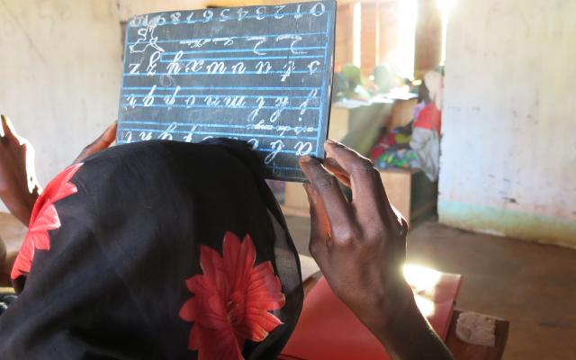 Fatima* writes the letter “e” on a small blackboard, during a literacy lesson at the headquarters of Bria’s Women Leaders Association, in the heart of the Central African Republic. She was raped by a member of an armed group while she was collecting firewood in the bush. Credit: Godet, Oxfam Fatima* writes the letter “e” on a small blackboard, during a literacy lesson at the headquarters of Bria’s Women Leaders Association, CAR. Credit: Godet, Oxfam