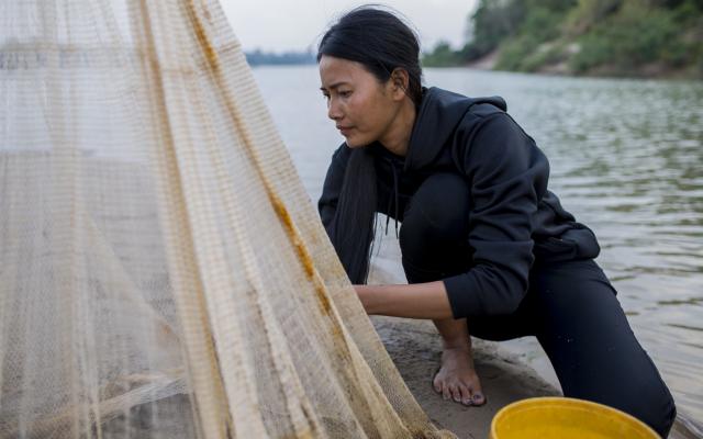 Hong Rany (26) checks a net for fish near her home on Chrem Island out in the middle of the Mekong River.