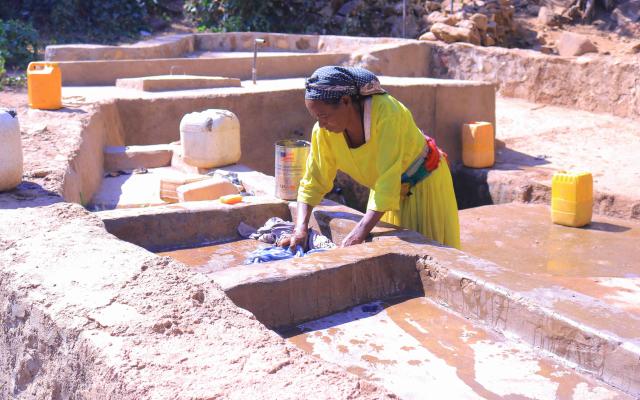 Ms. Feleg G/mariam washes clothes at Meshano spring water point in Birhan kebelle, Tsimbla woreda, Tigray, after the spring was rehabilitated.