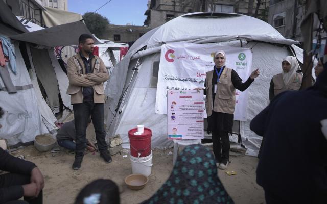 Oxfam partner health promoters leading a health promotion session attended by Niveen, a WASH program participant.