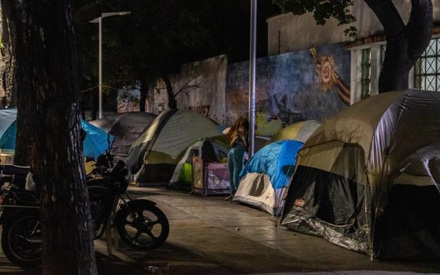 At night, families gather outside Andrés Bello Secondary School seeking safety. Unable to return home, they remain out in the open. 