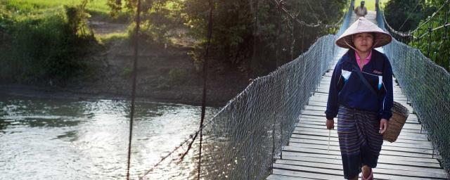 El pueblo de Nathen está conectado con los campos de arroz, el vivero de peces y otros campos de donde los aldeanos obtienen sus suministros de alimentos, por un estrecho puente colgante sobre el río Nam Lik, . Tineke D'haese / Oxfam