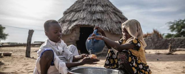 Mahamat y Sara se lavan las manos en la puerta de su casa en la comunidad de Kamkalaga. En esta región de Chad, donde los recursos de agua son escasos, Oxfam ha rehabilitado dos pozos e instalado un tanque en el centro de salud. Crédito: Pablo Tosco / Oxfam Intermón