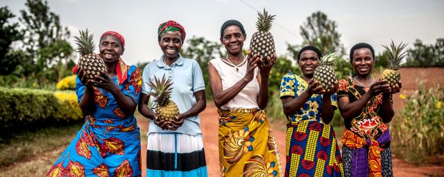 Tuzamurane cooperative members stand outside the cooperative centre in Eastern Rwanda, Kirehe District.