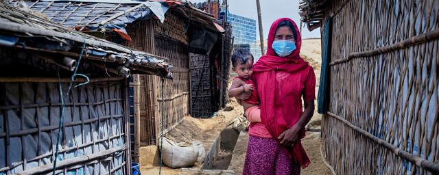 Nur Jahan* with her daughter Ismat* is walking through the narrow alley beside her tent. Rohingya refygee camp. Cox's Bazar, Bangladesh