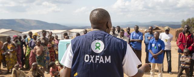 Pascaline, public health officer, shows the community at the Mwaka IDP site, DRC, how to use a new handwashing station innovated by Oxfam.