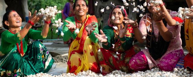 Women tossing garlic crops in a fun and spirited way.