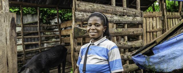 Marie N'simire, mother of two living in Tshazi, trader and farmer participating in the Oxfam BMZ project having received a pig, seeds, and agricultural tools.