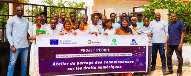 Participants at Forum Civil's workshop on digital rights in Bignona, Senegal holding a ReCIPE project banner while posing for a photo. 