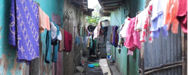 The alley outside Achawach Berhanu’s home is a ribbon of shade between teal walls.