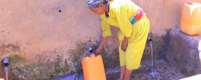 Ms. Feleg G/mariam, 65, fills a jerrycan at Meshano spring water point in Birhan kebelle, Tsimbla woreda, Tigray, after the spring was rehabilitated.
