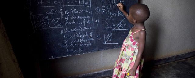 Ecolière devant un tableau noir dans une salle de classe de Kigali, Rwanda. Photo : Simon Rawles