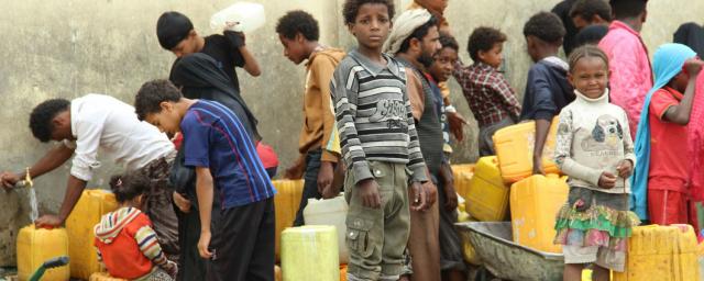 Displaced children in Yemen wait together and collect water Displaced children in Yemen wait and collect Water