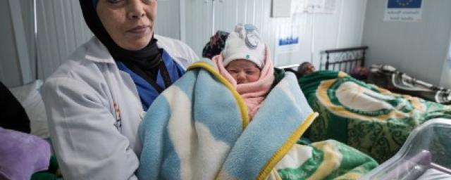 A doctor holds a new born baby in a maternity centre in Za'atari refugee camp, Jordan A doctor holds a new born baby in Za'atari camp, Jordan