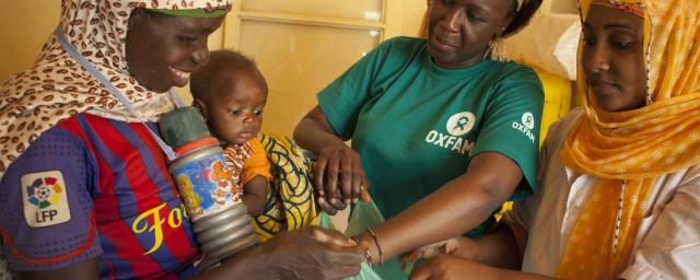 A mother and her child who’s suffering with malnutrition, receive a hygiene kit. Kits and practice of good hygiene can reduce treatment duration for a child with moderate malnutrition from four to two weeks. Photo credit: Abbie Trayler-Smith/Oxfam