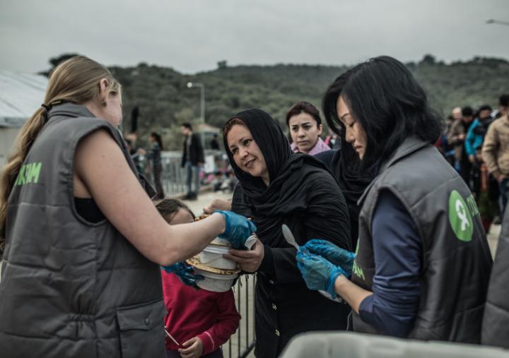 Un grupo de voluntarios de Oxfam entrega alimentos a migrantes y refugiados que llegan a Lesbos, Grecia. Crédito: Pablo Tosco / Oxfam