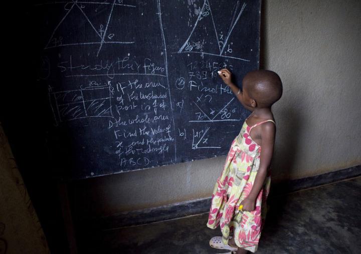 Una niña escribiendo en una pizarra, en una escuela de Ruanda. Foto: Simon Rawles / Oxfam