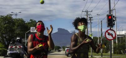 Chicos con mascarillas hacen malabarismos con pelotas de tenis en los semáforos de Barra da Tijuca, Río de Janeiro. Brasil.