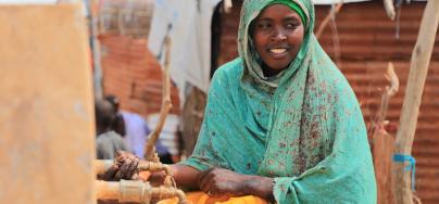 Aqiqah, a mother of three collects water from an Oxfam-constructed water tank in Beledweyne, significantly reducing the burden on women and girls who previously had to walk long distances to access water.