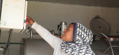  Berehane Eshete, 36, a mother of three and manager of the Andenet (Cheki Andinet) Dairy Cooperative Association in Debre Birhan, switches on the milk chiller to keep fresh deliveries cool and safe. Photo: Liban Hailu/Oxfam