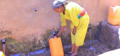 Ms. Feleg G/mariam, 65, fills a jerrycan at Meshano spring water point in Birhan kebelle, Tsimbla woreda, Tigray, after the spring was rehabilitated.