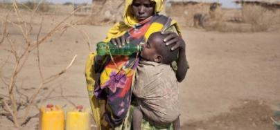 Fathima gives her son a drink of clean water, provided by Oxfam , Ethiopia