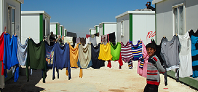 syriarefugeepercsumm.png Boy walks past washing line Zaatari Refugee Camp