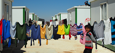 Boy walks past washing line Zaatari Refugee Camp